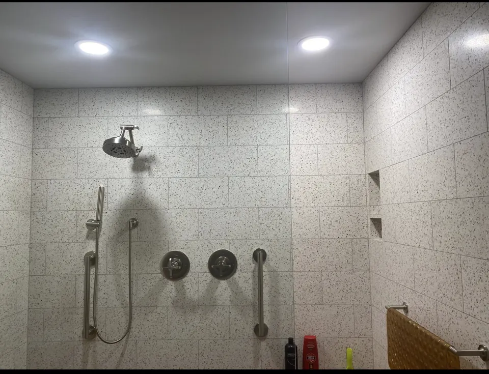 Bright, clean speckled-tile walk-in shower